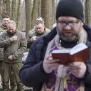 Un pope (pretre) orthodoxe donne une messe au profit des volontaires dans une forêt de Kharkiv. Photographie de Frederic Petry / Hans Lucas.